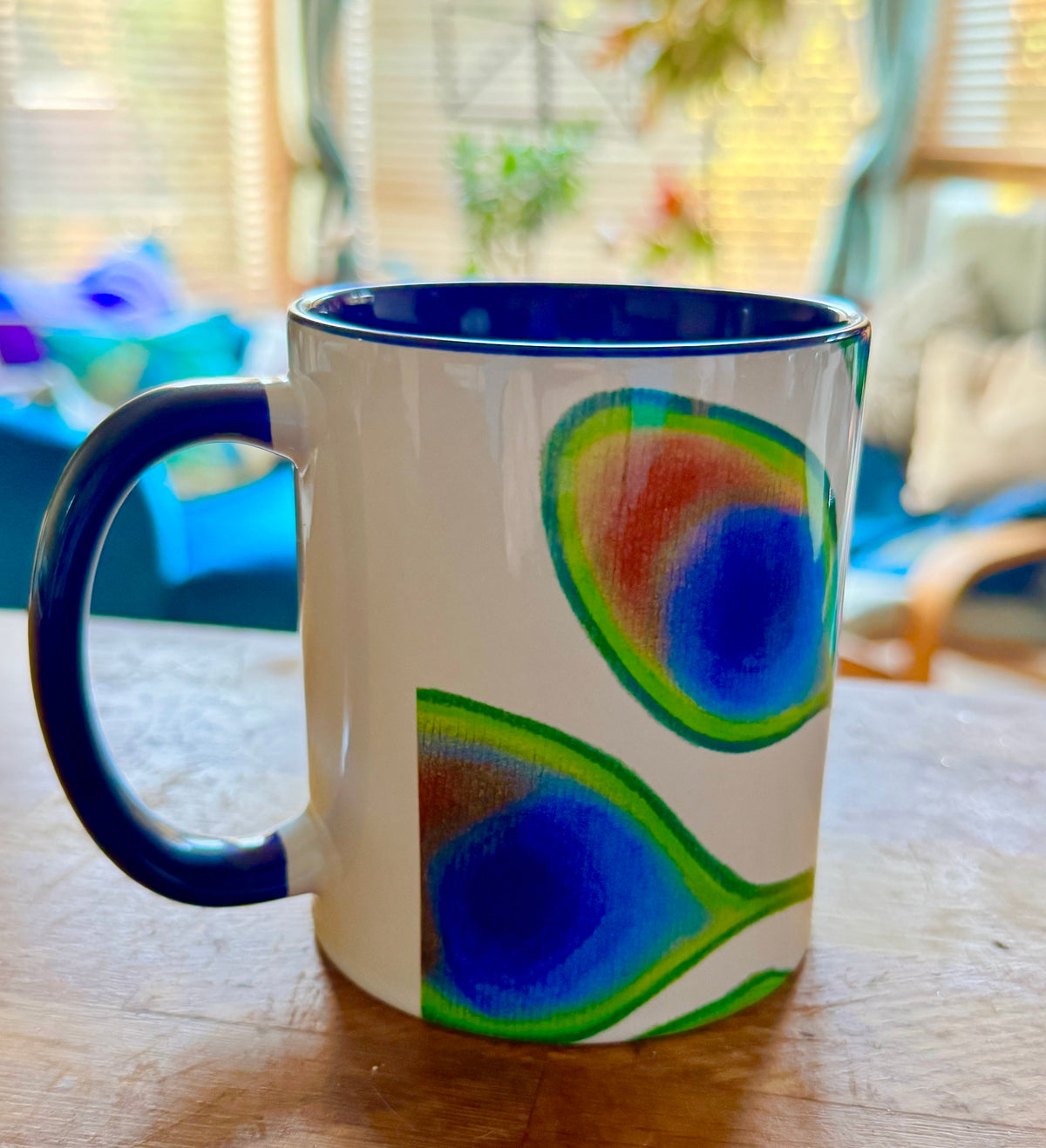 Sassy peacock coffee mug with deep blue handle and interior