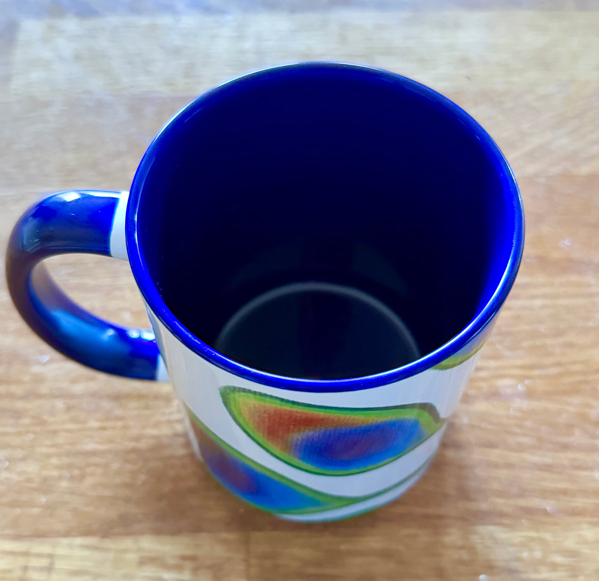 Sassy peacock coffee mug with deep blue handle and interior